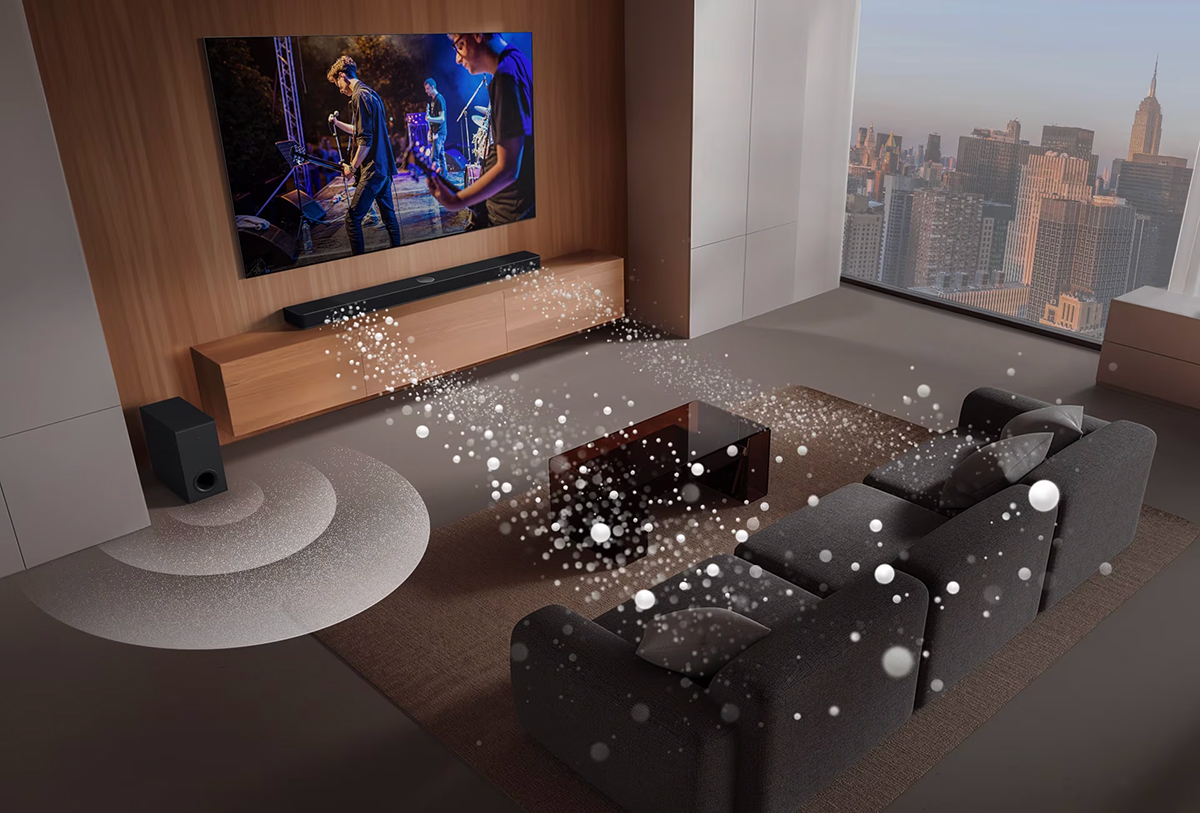 Τα LG Soundbar, LG TV και subwoofer βρίσκονται σε ένα σαλόνι με την οθόνη να δείχνει μια μουσική παράσταση. Δύο λευκά ηχητικά κύματα από σταγόνες προβάλλονται από το soundbar και ένα subwoofer, δημιουργώντας ένα ηχητικό εφέ από το κάτω μέρος.
